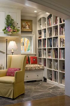 a living room filled with lots of furniture and bookshelves next to a window