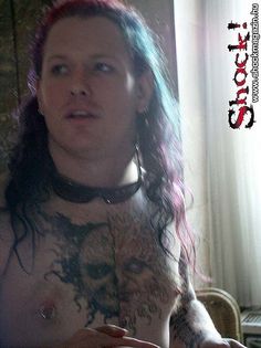 a man with long hair and tattoos on his chest