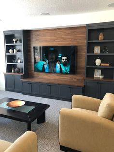 a living room filled with furniture and a flat screen tv mounted to the side of a wall