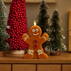 a gingerbread man is standing in front of some christmas trees