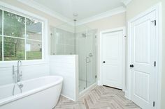 a bathroom with a tub, shower and window