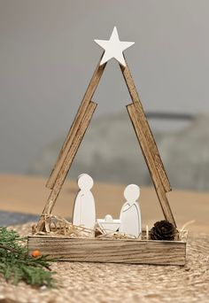 the nativity scene is made out of wood and has a white star on top