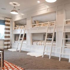 a room with bunk beds and ladders on the wall in front of a window