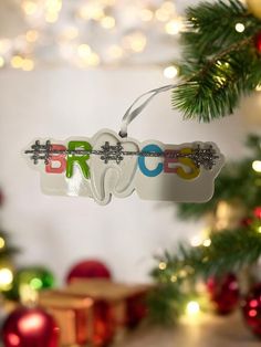 an ornament hanging from a christmas tree with the olympic symbol on it's side