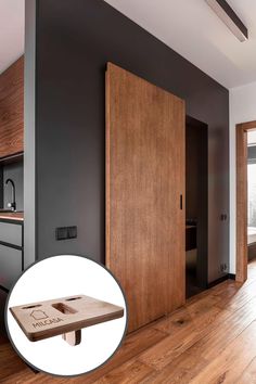 an open wooden door in a room with wood flooring and black walls on the wall