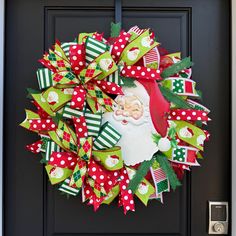 a christmas wreath with santa claus on it is hanging on the front door to give as a decoration