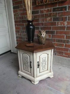 an owl statue sitting on top of a white cabinet next to a brick wall and door