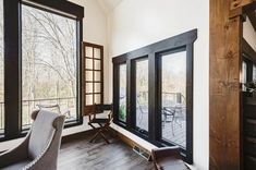 a living room filled with furniture and large windows