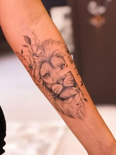 a lion tattoo on the arm with flowers