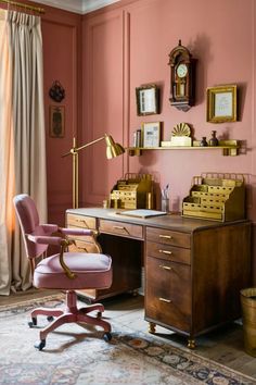 an office with pink walls and gold accents