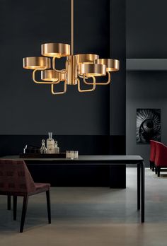 a modern chandelier hanging from the ceiling in a black and gold dining room