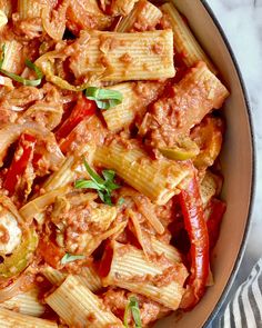 a bowl filled with pasta and meat covered in marinara sauce on top of a table