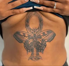 a woman with a butterfly tattoo on her stomach