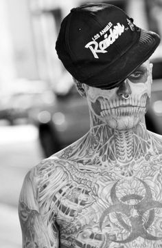 a man with tattoos and a hat on his head