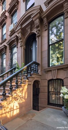 an apartment building with wrought iron balconies and railings on the front door