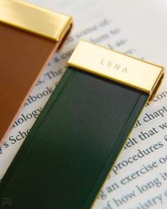 two books with nameplates sitting on top of an open book page in front of them