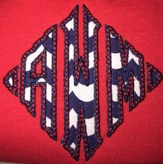 an embroidered red sweater with black and white letters on the front that says, am