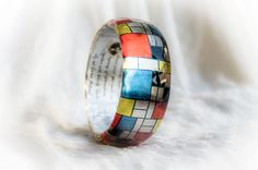 Mondrian Resin Bangle, Famous Art Jewelry, Resin Bracelet Mondrian Born 7 March 1872 - Died 1 February 1944 (aged 71) Middle design thick bangle - Height of the bangle - 3cm/1.18inches Pieter Cornelis Mondrian was a famous abstract Cubism painter, born in the Netherlands. His most recognized works are abstract paintings of colored squares, rectangles, and thick black lines.We love his minimal art , and that's why we decided to create a bracelet with his design in red, yellow, white and blue squa Multicolor Wearable Art Bracelet, Multicolor Wearable Art Bangle Bracelets, Multicolor Bangle Bracelets In Wearable Art Style, Multicolor Wearable Art Bracelet For Gift, Artistic Multicolor Bangle Bracelet, Artistic Multicolor Cuff Bracelet Gift, Artistic Multicolor Cuff Bracelet As Gift, Artistic Multicolor Cuff Bracelet As A Gift, Artistic Handmade Bangle Bracelets