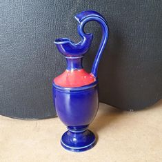 a blue and red vase sitting on top of a counter