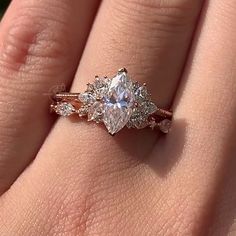 a woman's hand with a ring on it and an engagement ring in the middle