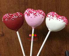 three heart shaped lollipops with pink and white sprinkles on them