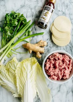 the ingredients to make this dish include lettuce, meat and sauce on a marble surface