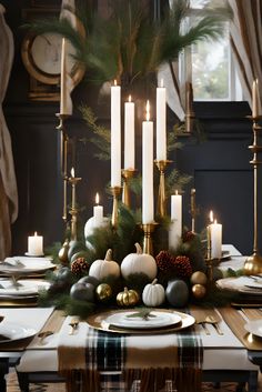 a dining room table decorated for christmas with white and gold decorations, pine cones, evergreens, candlesticks and plaid napkins