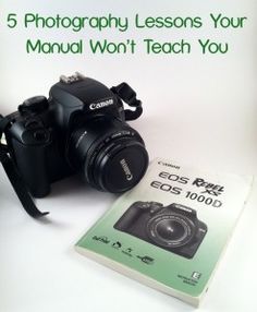 a camera sitting on top of a white table next to a manual for how to use it