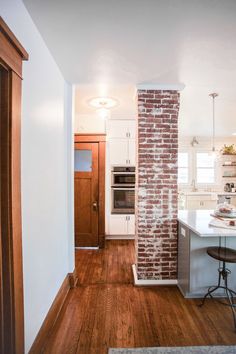 a kitchen with an oven, stove and bar stools in front of the counter