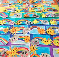 children's art work is displayed on the table with rainbows and sunflowers