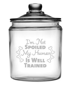 a glass jar that has a dog on the front and words written in grey ink