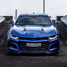 a blue chevrolet camaro is parked in front of some steps