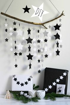 a white and black christmas decoration with stars hanging from it's side on a mantle