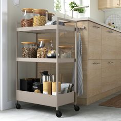 a kitchen filled with lots of food and containers on top of a metal cart in front of a counter