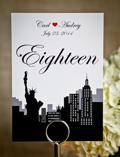 a place card holder with a statue of liberty on it and a cityscape in the background