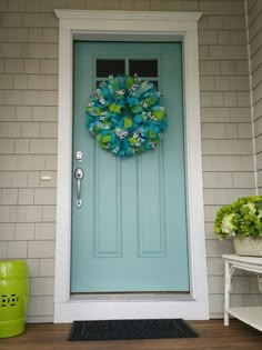 a blue front door with a green wreath on it