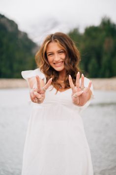 a woman making the peace sign with her hands