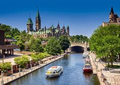 boats are traveling down the river in front of a castle