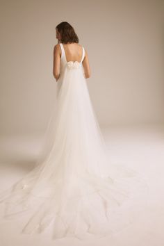 a woman in a white wedding dress is standing back to back with her hands on her hips