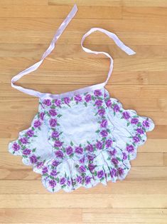 "The cutest small vintage white and purple floral handkerchief half apron! It appears to be handmade. SO adorable :) MEASUREMENTS Length from top to bottom: 16.25\" Length: 26\" at widest; 11\" at the waist Condition: Good. There is some evidence of wear and tear consistent with age (some minor pinholes, snags, a couple tears near stitching, the stitching is wonky in some areas).  All items are pre-loved and sold AS-IS.  Please feel free to ask any questions! :)" Floral Handkerchief, Vintage Handkerchiefs, Half Apron, Linen Apron, Purple Floral, Side Hustle, Dining Linens, White Vintage, The Cutest