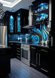 a kitchen with black cabinets and blue glass backsplash