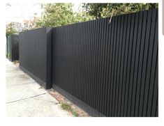 a black fence is next to a sidewalk