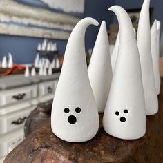 three white ceramic figurines sitting on top of a wooden table