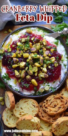 cranberry whipped feta dip in a bowl surrounded by bread and crackers