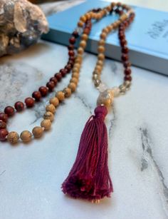 This mala has been in the works for a while. When I discovered these striking red rock beads--yes, you read that right--I felt compelled to create a Sedona-inspired mala. The vortex energy of Sedona deeply inspired me, and this mala came together in a unique and funky way. I absolutely love it, and I hope you do too! Red jasper is full of iron that has protective properties. It offers insight during difficult times and helps to strengthen our personal boundaries. It is a strong grounding stone a Red Bohemian Mala With Round Beads, Bohemian Red Mala With Round Beads, Red Hand-strung Spiritual Mala, Bohemian Red Mala For Gift, Red Hand-strung Mala For Healing, Red Handmade Mala For Healing, Red Mala For Meditation, Red Beaded Mala For Meditation, Handmade Red Mala For Healing