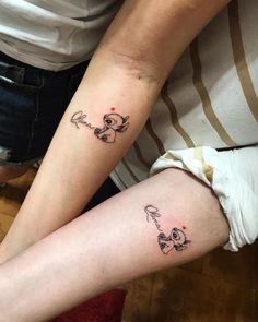 two people with matching tattoos on their legs, one is holding the other's arm