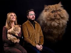 a man and woman sitting next to a cat