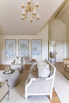 a living room filled with furniture and a chandelier hanging from it's ceiling