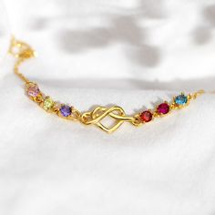 DESCRIPTIONEmbrace a symphony of memories and love with this Heart Knot Bracelet, customizable with up to 8 birthstones. Each gem, a vivid representation of a cherished loved one. Let this beautiful bracelet share the stories of your shared memories and never ending love. The bracelet's heart knot, a timeless symbol of unbreakable bonds, intertwines these precious gems, reflecting an eternal connection with loved ones. This elegant piece is more than just jewelry; it's a wearable narrative of li Heart Knot Bracelet, Heart Knot, Timeless Symbol, Birthstone Bracelet, Knot Bracelet, Birthstone Bracelets, Premium Gift, Gift Packs, Precious Gems