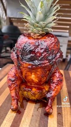 a pineapple is sitting on top of a chicken that has been grilled to look like a turkey